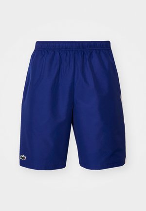 Marineblauwe sportshorts met een elastische tailleband, voorzien van een klein logo op de linkerzoom en een gladde, lichte textuur.