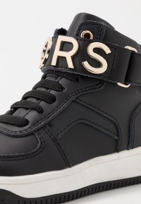 Černé vysoké tenisky z umělé kůže, s výrazným zlatým páskem s nápisem "ORS", černými tkaničkami a texturovanou podrážkou.