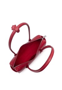 Sac à main en cuir rouge avec deux anses et une fermeture éclair ouverte montrant un intérieur vide sur fond blanc.
