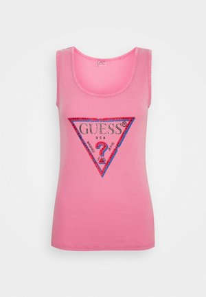 Débardeur rose côtelé sans manches avec un logo GUESS USA en sequins rouges et violets, ainsi qu'un point d'interrogation dans un triangle sur le devant.