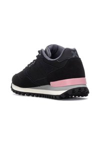 Zapatilla deportiva negra con parte superior de malla, acentos de ante, media suela gris y detalle en el talón rosa. Suela de goma con relieve para tracción.