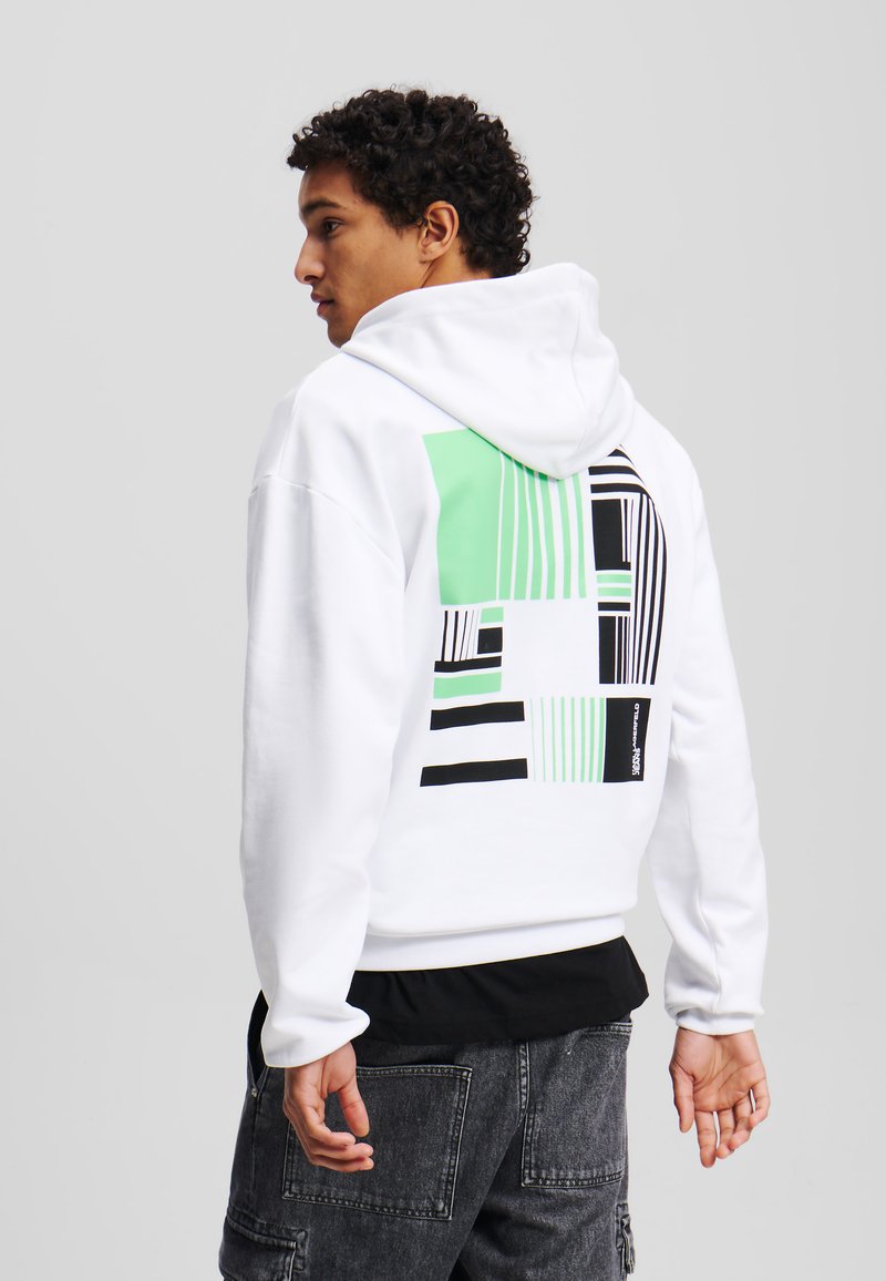 Weißer Kapuzenpullover mit grünen und schwarzen geometrischen Mustern auf der Rückseite. Verfügt über eine Kordelzugkapuze und gerippte Bündchen. Glatte Stofftextur.
