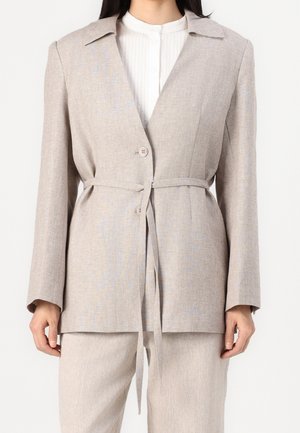 Beige linneblandad blazer med långa ärmar, snedkrage, bälte i midjan och två knappar; slät struktur och minimalistisk stil.