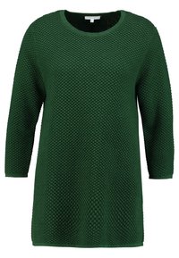 Maglione verde a maniche lunghe in tessuto texturizzato con scollo rotondo; presenta una vestibilità ampia e un motivo intrecciato su tutta la superficie.