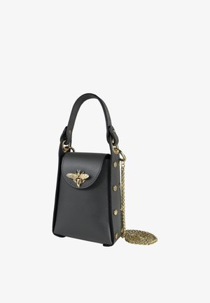 Schwarze Mini-Handtasche aus Leder mit Tragegriff oben, goldener Bienenverzierung auf der Klappe, goldenen Nieten an den Seiten und einem gewickelten goldenen Kettenriemen.