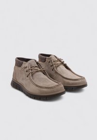 Botas de tobillo de ante marrón con cuello de tela texturizada, punta redonda y cordones en la parte delantera. Suela de goma gruesa para mayor agarre y comodidad.
