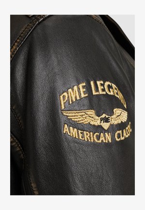 Schwarze Lederjacke mit gesticktem Logo von "PME Legend" und "American Classic" in Gold, das detaillierte Nähte hervorhebt.