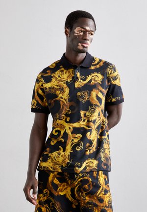 Polo noir avec des motifs en or enroulés complexes, comportant un col et des manches courtes. Fabriqué en tissu texturé, associé à un bas assorti.