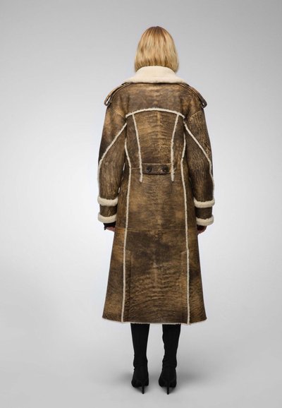 Long brown shearling coat with a white fur collar, featuring a structured design, visible stitching, and two buttons on the back.