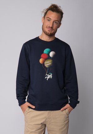 Navyblauer Pullover mit einem Astronauten, der bunte Planetballons hält, entworfen mit lebhaften Texturen und Mustern.