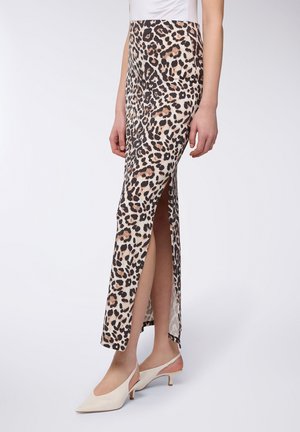 Gonna maxi leggera con stampa leopardata e spacco laterale, con vita aderente e texture liscia. Abbinata a décolleté con tacco a scomparsa color crema.