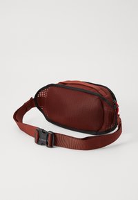 Sac banane en tissu brun avec un panneau en maille et une fermeture éclair noire. Doté d'une sangle réglable robuste et d'une fermeture en plastique bien visible.