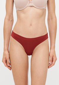 Rode bikini slipjes gemaakt van zachte, elastische stof, met een lage taille en een minimalistisch ontwerp met gladde randen.