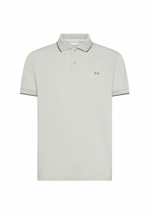 Polo de manga corta gris claro con dos botones, ribete negro en el cuello y las mangas, y pequeño logo negro de triángulo y X en el pecho izquierdo.