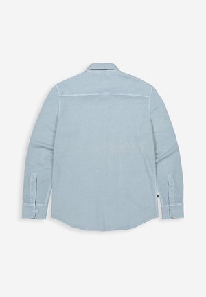 Lichtblauw overhemd met lange mouwen en knopen, plat gelegd met de achterkant naar boven, met kraag, knoopmanchetten en naaddetails op een effen witte achtergrond.