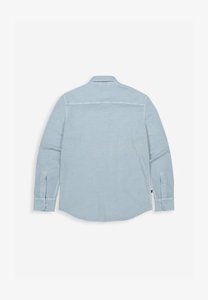 Hellblaues langärmliges Hemd mit Knöpfen, flach ausgelegt, zeigt die Rückseite mit Kragen, geknöpften Manschetten und Nahtdetails auf schlichtem weißem Hintergrund.