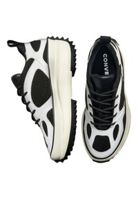 Schwarz-weiße Sneakers mit Mesh-Einsätzen, dicken weißen Sohlen und strukturierten schwarzen Gummisohlen. Verfügt über ein Schnürdesign und ein Logo auf der Zunge.