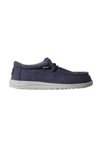 Chaussure décontractée bleu marine à enfiler avec semelle en caoutchouc blanche et détail lacet noir, vue de côté sur fond blanc.