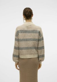 Lichtbeige gebreide trui met donkerblauwe horizontale strepen, geribde manchetten en boord. Heeft een zachte textuur en een cropped ontwerp.