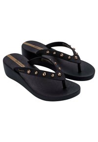 Infradito neri a zeppa con una soletta testurizzata, dotati di una cinturino a forma di V decorato con borchie in bronzo e una banda dorata.