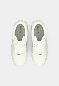Sneaker bianche con tomaia in pelle liscia, lacci, dettagli in metallo dorato e soletta imbottita. Presenta un dettaglio con il logo di lato.