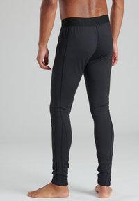 Zwarte sportleggings met een soepele textuur, elastische tailleband en platte naden voor comfort. Geen zichtbare patronen of logo's.