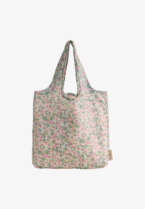Bolsa de tela reutilizable con estampado floral en rosa y amarillo, con hojas verdes suaves y etiqueta de marca adjunta en el lateral.