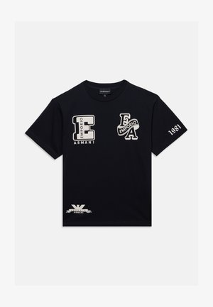 Sort t-shirt med korte ærmer med hvide Emporio Armani-logoer og tekst, inklusive store styliserede bogstaver foran og "1981" på højre ærme.