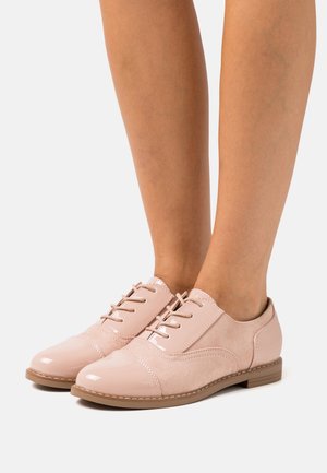 Scarpe in pelle rosa con lacci, caratterizzate da una punta in vernice e dettagli in suede, con una forma arrotondata e suola bassa.