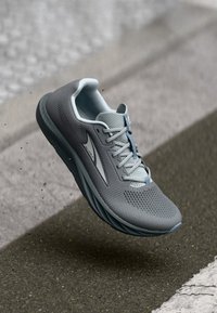 Gray athletic shoe featuring a breathable mesh upper, lace closure, and a cushioned sole with light blue accents.