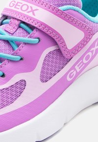 Μωβ και ροζ αθλητικό παπούτσι Geox με βεραμάν κορδόνια, πλέγμα και συνθετικά υλικά, λουράκι με βέλκρο και λεπτομέρεια λευκής σόλας.