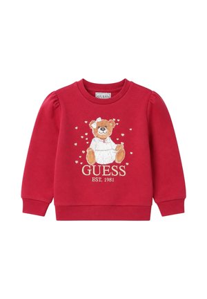 Felpa rossa per bambini con un orsacchiotto che indossa un vestito bianco e un fiocco, circondato da piccoli cuori, e testo "GUESS EST. 1981" sotto.
