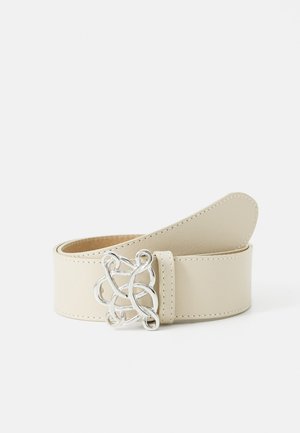 Crème leren riem met gedetailleerde zilveren lusgesp, keurig opgerold tegen een witte achtergrond.