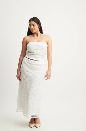 Biely háčkovaný dvojdielny outfit so strapless topom a dlhou sukňou. Výrazné čipkové vzory a textúrovaná látka po celom oblečení.