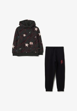 Sudadera con capucha en gris oscuro con patrones de estrellas multicolores y relámpagos, combinada con pantalones jogger negros que presentan un logo de relámpago rojo.