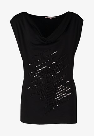 Czarna bluzka z krótkim rękawem i drapowanym dekoltem, z cekinowymi zdobieniami z przodu. Połączona z dopasowanymi niebieskimi jeansami i czarnymi szpilkami.