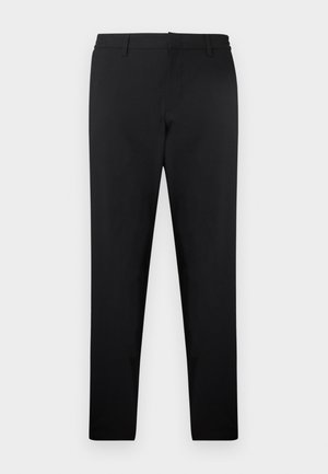 Crne uske hlače s uprtačima za remen, prednjim patentnim zatvaračem i minimalnim detaljima, prikazane položene na svijetloj podlozi.