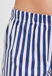 Blue and white striped fabric with an elastic waistband. The texture appears soft and lightweight, suitable for casual wear.
