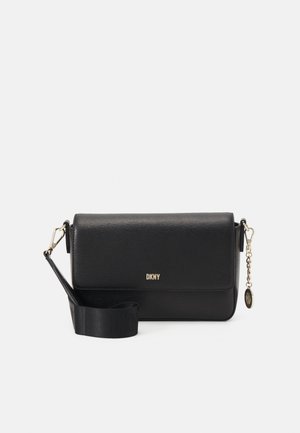 Schwarze Leder-Umhängetasche mit goldenem DKNY-Logo, verstellbarem breitem Riemen und goldener Kette mit rundem Anhänger an der Seite.