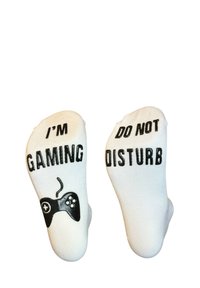 Calze bianche con la scritta "STO GIOCANDO" su una e "NON DISTURBARE" sull'altra, con una grafica nera di un controller da gioco. Materiale in maglia morbido.