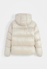Veste en duvet de couleur beige clair avec une texture brillante et matelassée, capuche ajustée et poignets côtelés. Présente des coutures horizontales et une coupe décontractée.