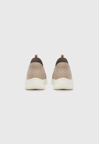 Sneaker slip-on con tomaia in tessuto texturizzato color beige, colletto a maglia marrone in contrasto e suola in gomma bianca. Design minimalista, senza chiusure visibili.