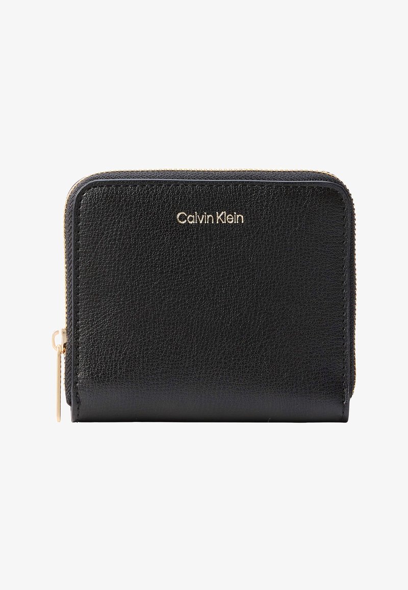 Μαύρο δερμάτινο πορτοφόλι Calvin Klein με χρυστό φερμουάρ και λογότυπο, συμπαγές και ορθογώνιο, με φερμουάρ σε τρεις πλευρές.