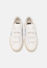 Hvit lær sneakers med lyseblå detaljer, med tre borrelåser, en teksturert overflate og en beige gummisåle.