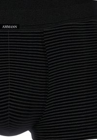 Black boxer briefs featuring a textured ribbed pattern and thin, horizontal stripes, with a smooth waistband and a fitted design.