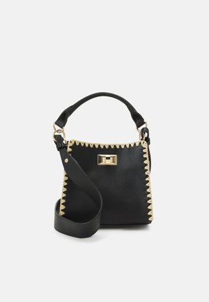 Sac à main en cuir noir avec des coutures en zigzag accentuées de doré, poignée supérieure, sangle réglable et un détail de fermoir rectangulaire à l'avant.