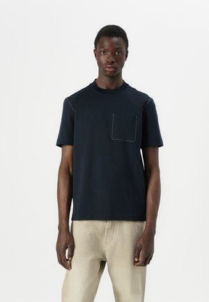 Navy cotton t-shirt featuring a crew neck, short sleeves, and a patch pocket with contrasting white stitching. Smooth, lightweight fabric.
