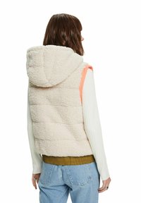 Nepbontjesvest in crème met een oranje accent en capuchon. Heeft een gewatteerd ontwerp, textuurrijk materiaal en een geribbelde zoom.