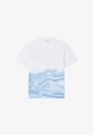 T-shirt blanc à manches courtes avec un motif abstrait de vague bleue sur la moitié inférieure et une petite étiquette de marque à l'intérieur du col.