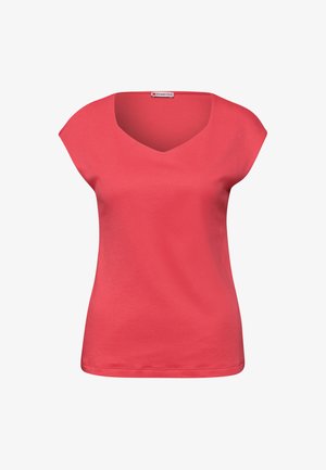 Koraalroze dames top met korte mouwen, een V-hals en een klein merkje aan de binnenkant van de halslijn.